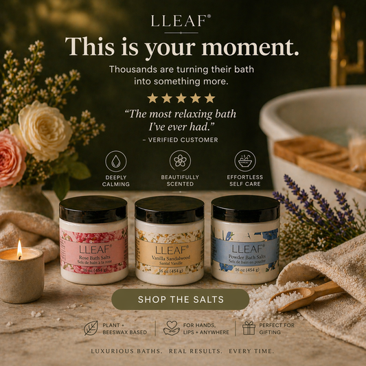 LEAF bath salts with a bathtub, flowers, and candle on a wooden surface.