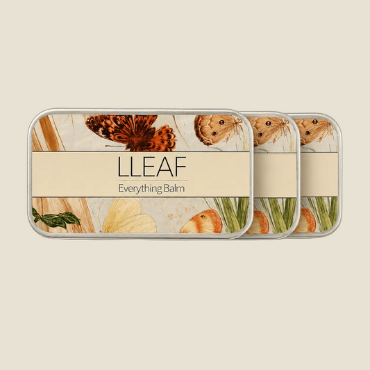 Three rectangular metal balm tins arranged in a row on a light beige background. The tins feature botanical illustrations of butterflies, leaves, and natural elements, with a cream-colored band across the center reading 'LLEAF Everything Balm'.