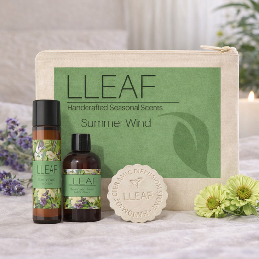 LLeaf handcrafted seasonal scents set with bottles, soap, and pouch on a soft surface with flowers.