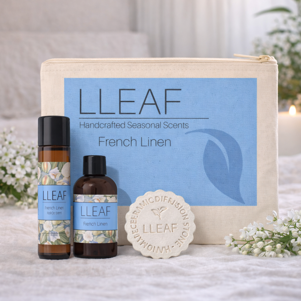 LLLeaf product set with bottles, a diffuser, and a soap on a textured surface with flowers.