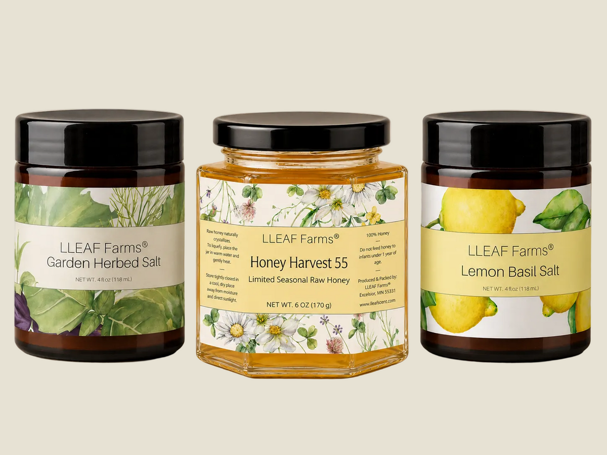 Three LLEAF Farms products arranged side by side on a warm beige background: Garden Herbed Salt, Honey Harvest 55, and Lemon Basil Salt. The center jar contains golden honey and is a hexagonal glass jar with a black lid.