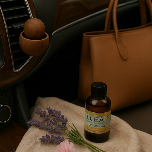 L'LEAF essential oil bottle with lavender and a pink flower on a car's console.
